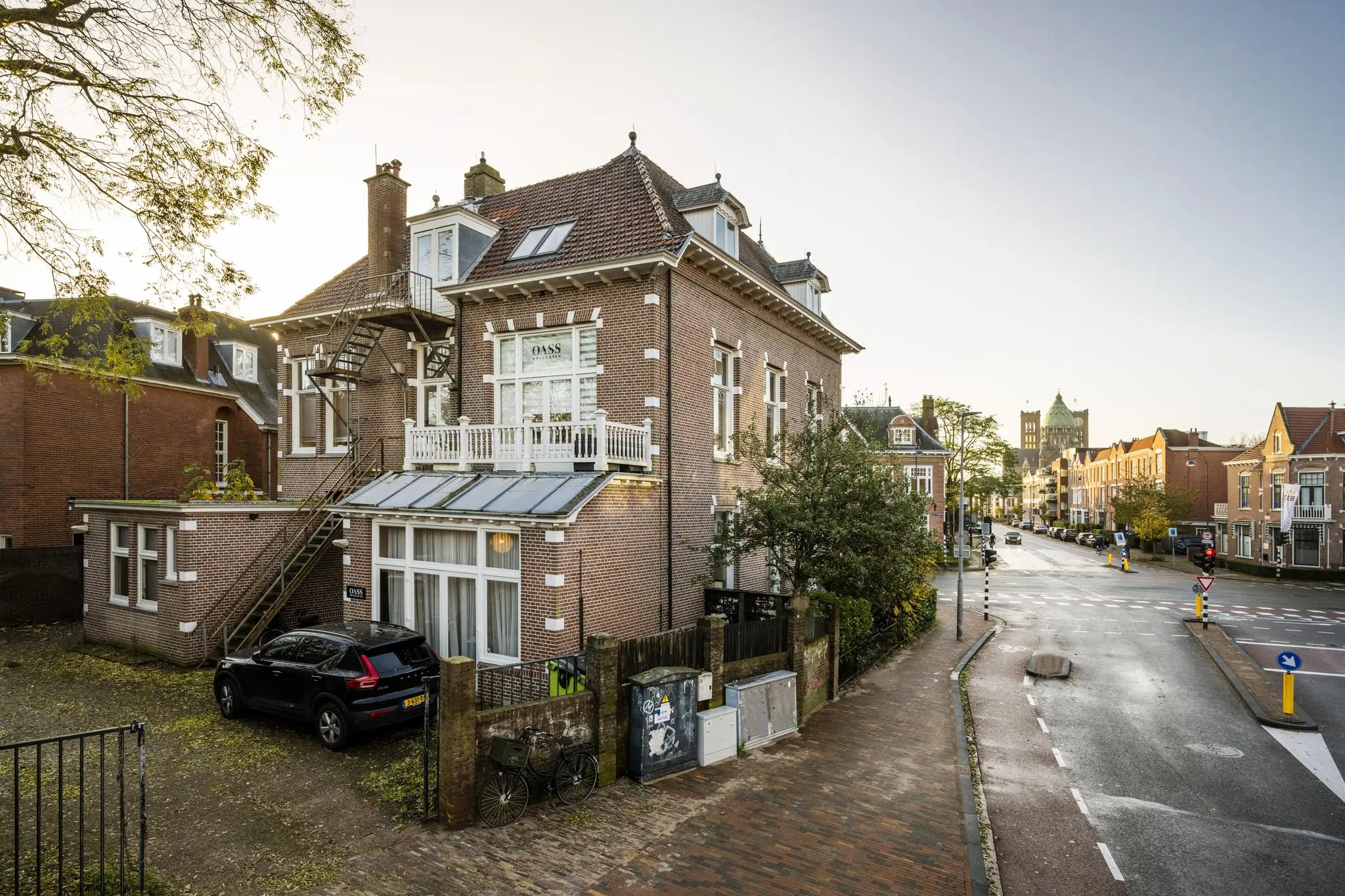 Hoekpand met trapgevel aan de Van Eedenstraat, met geparkeerde auto en zicht op een rustige straat in een historische woonwijk.